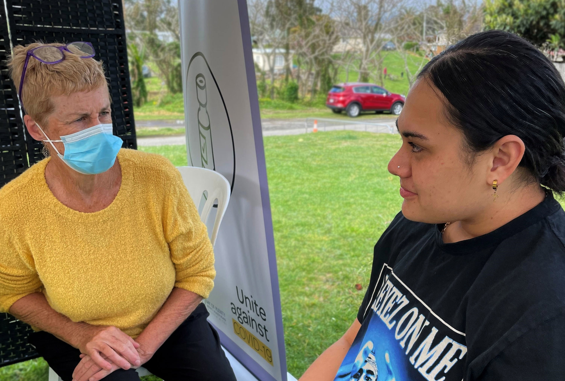 Paea Uiloa speaking with a vaccinator before receiving a dose of the Pfizer vaccine